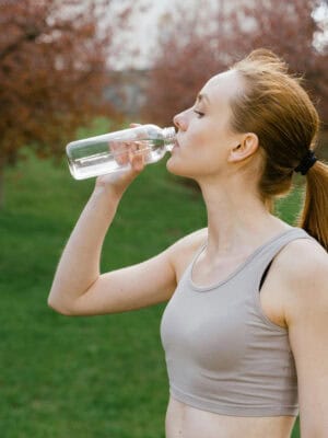 Photo by MART PRODUCTION from Pexels: https://www.pexels.com/photo/woman-in-activewear-drinking-a-bottle-of-water-7880192/
